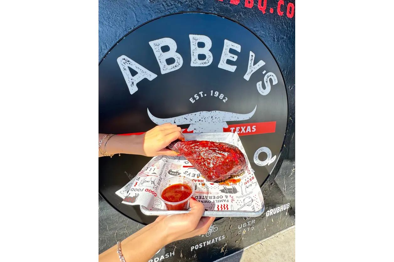 Texas-style smoked turkey legs from Abbey’s Real Texas BBQ prepared over real mesquite wood for Thanksgiving meals and catering.